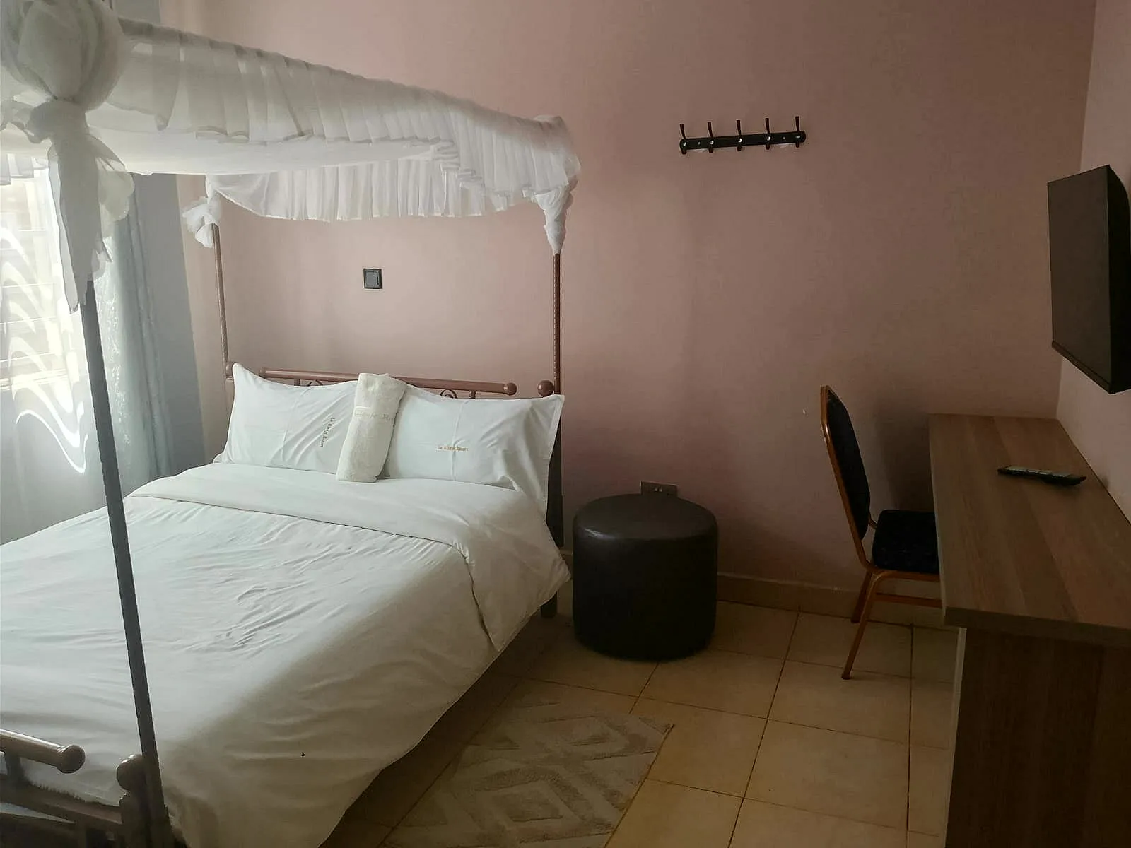 Double room with a four-poster bed, mosquito net, desk and TV